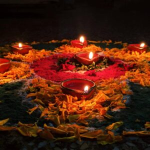 Vibrant Diwali rangoli with glowing oil lamps and flowers in New Delhi.